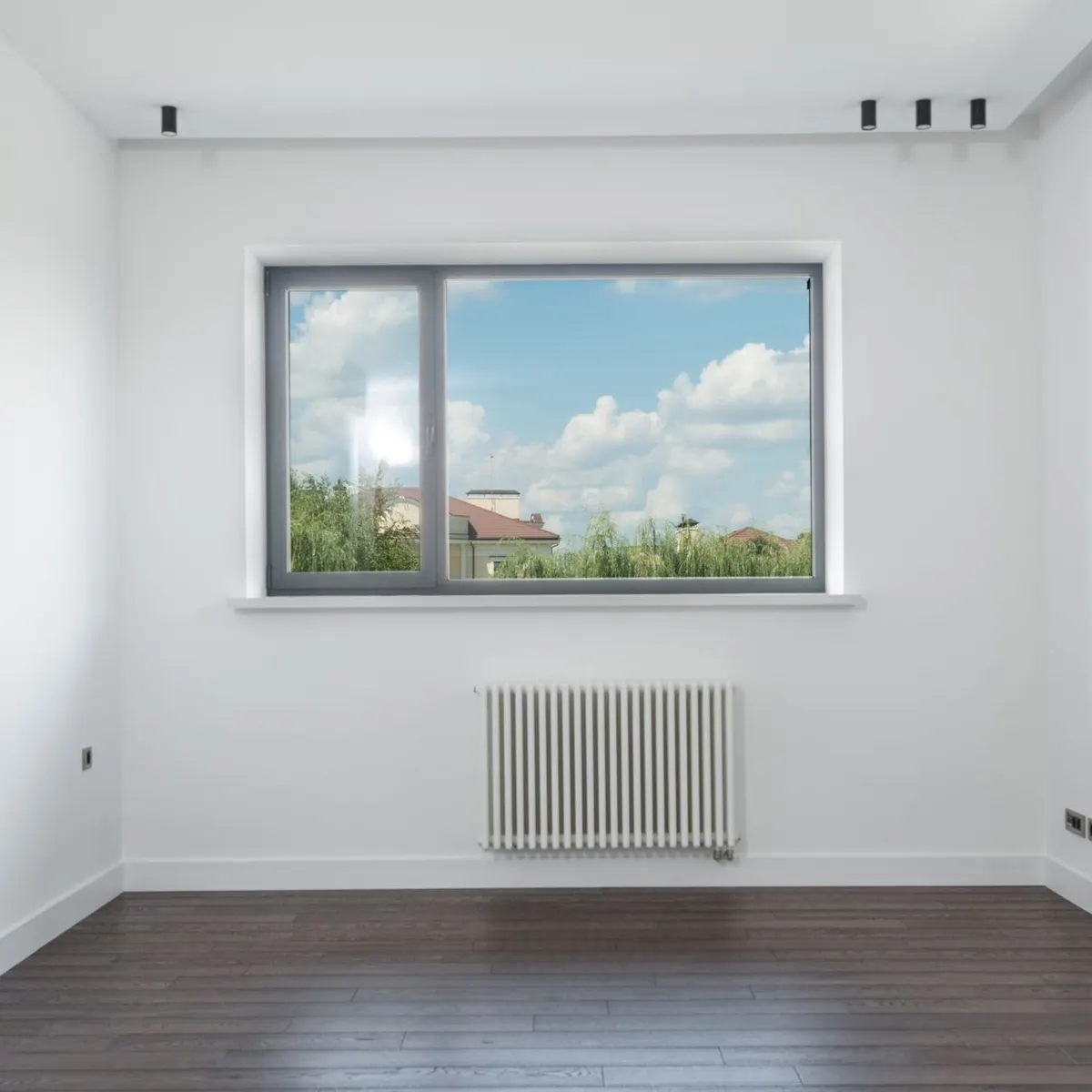 Sala clara com janela de correr de perfil escuro na parede e janela em fita acima
