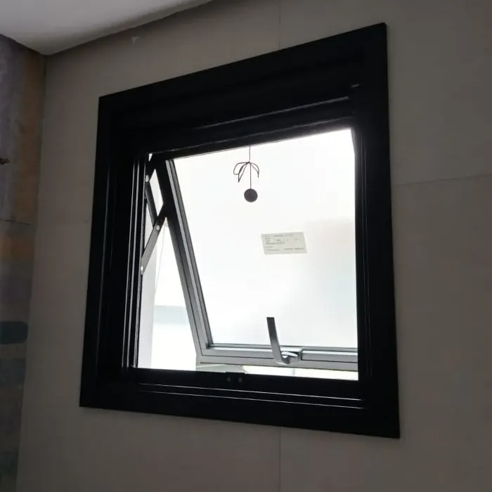 Janela maxim-ar de alumínio preto aberta, em banheiro de porcelanato claro